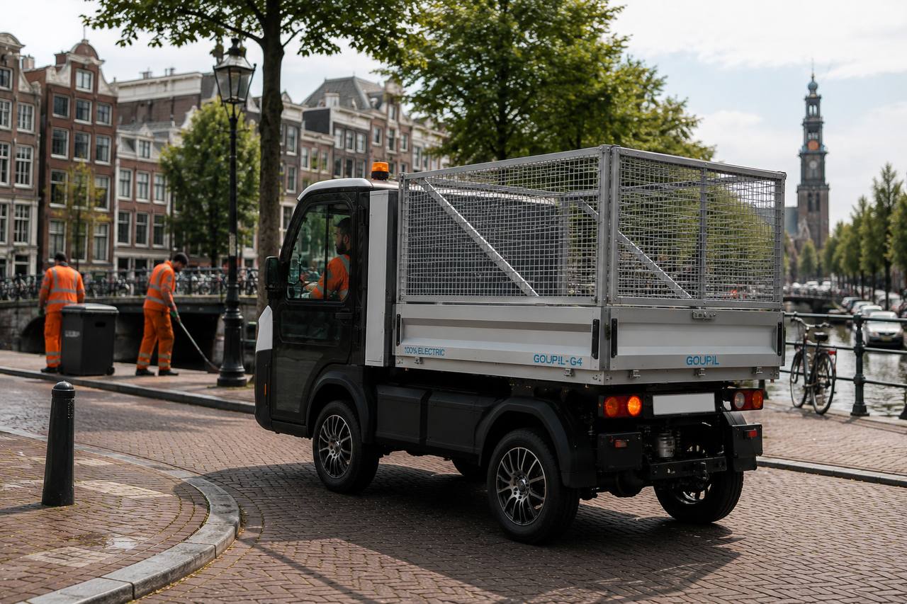 Compact elektrisch cleanup voertuig met afvalkooi in Amsterdamse binnenstad